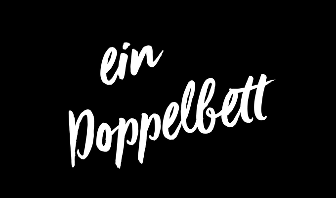 Typrografisch mit weißer Schrift vor schwarzem Grund dargestellt: „ein Doppelbett“.